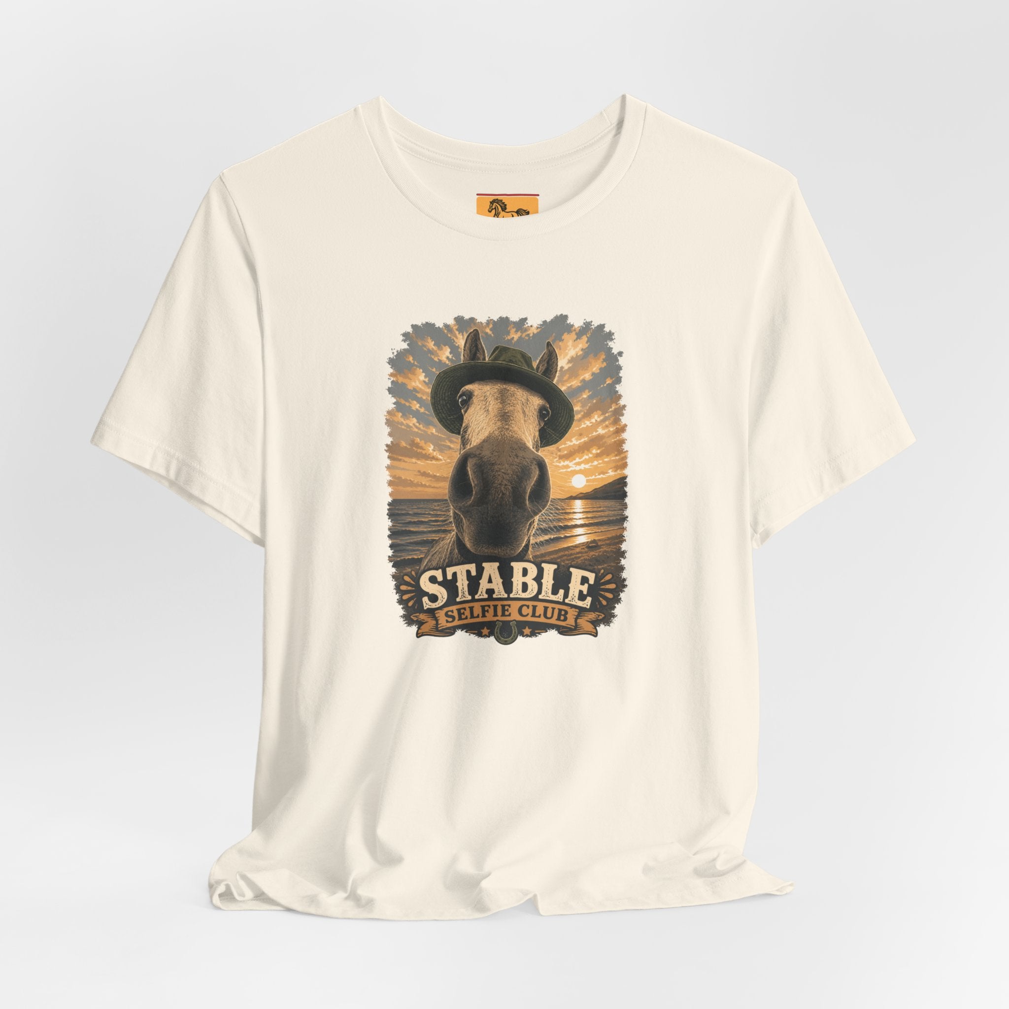 Stable Selfie Club unisex t-shirt  featuring original equestrian artwork of a horse wearing a hat taking a selfie at sunset on a beach, printed on Bella & Canvas 3001 tee by Hay there Horse Art.