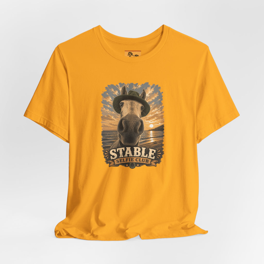 Stable Selfie Club unisex t-shirt in gold, featuring original equestrian artwork of a horse wearing a hat taking a selfie at sunset on a beach, printed on Bella & Canvas 3001 tee by Hay there Horse Art.