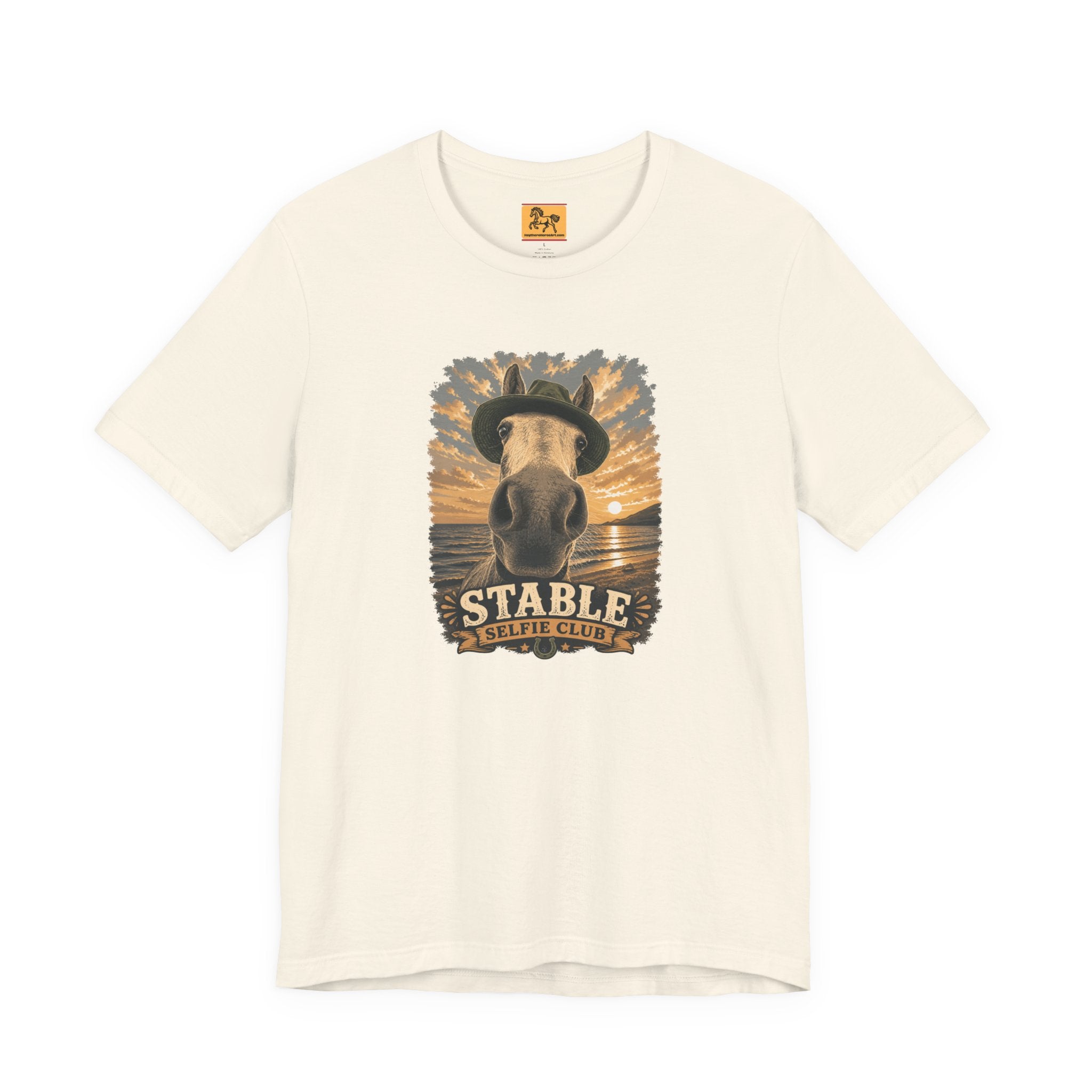 Stable Selfie Club unisex t-shirt in natural, featuring original equestrian artwork of a horse wearing a hat taking a selfie at sunset on a beach, printed on Bella & Canvas 3001 tee by Hay there Horse Art.