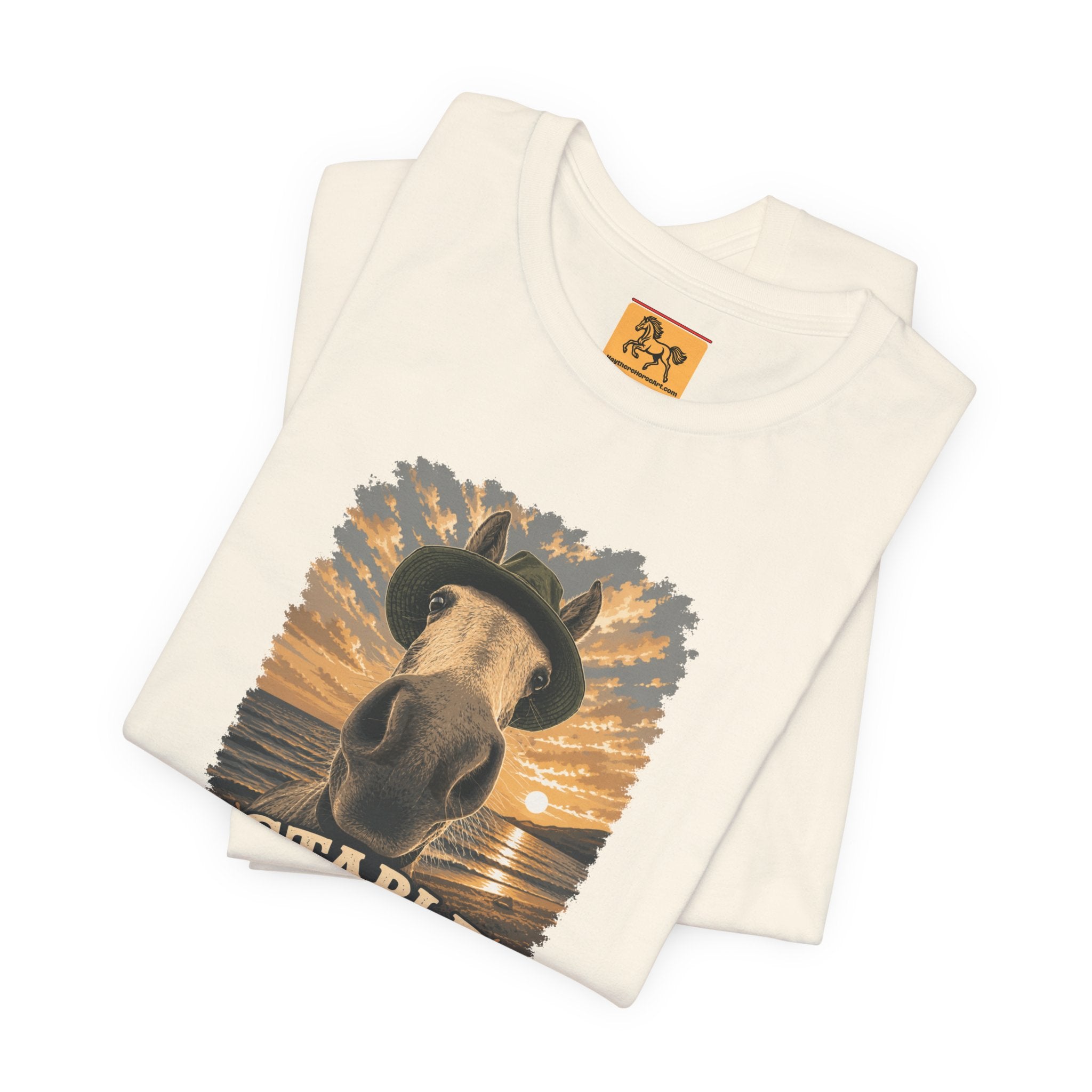 Stable Selfie Club unisex t-shirt in soft cream, featuring original equestrian artwork of a horse wearing a hat taking a selfie at sunset on a beach, printed on Bella & Canvas 3001 tee by Hay there Horse Art.