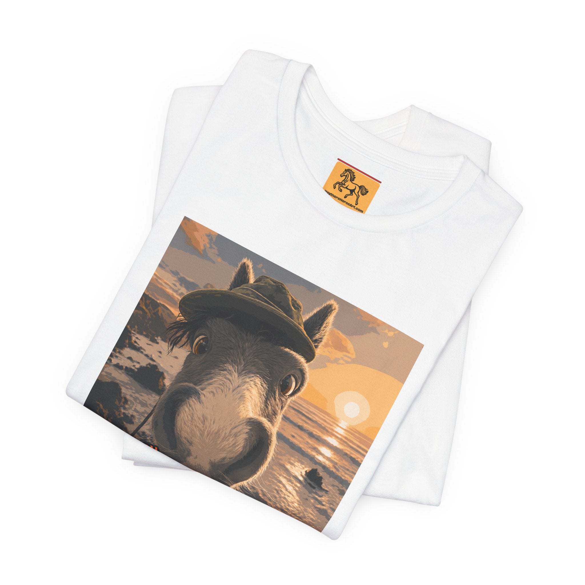 A Bella + Canvas 3001 unisex t-shirt featuring an illustrated horse taking a beach selfie at sunset, wearing a hat, with the words 'Loving my holiday XXX' in orange script. 