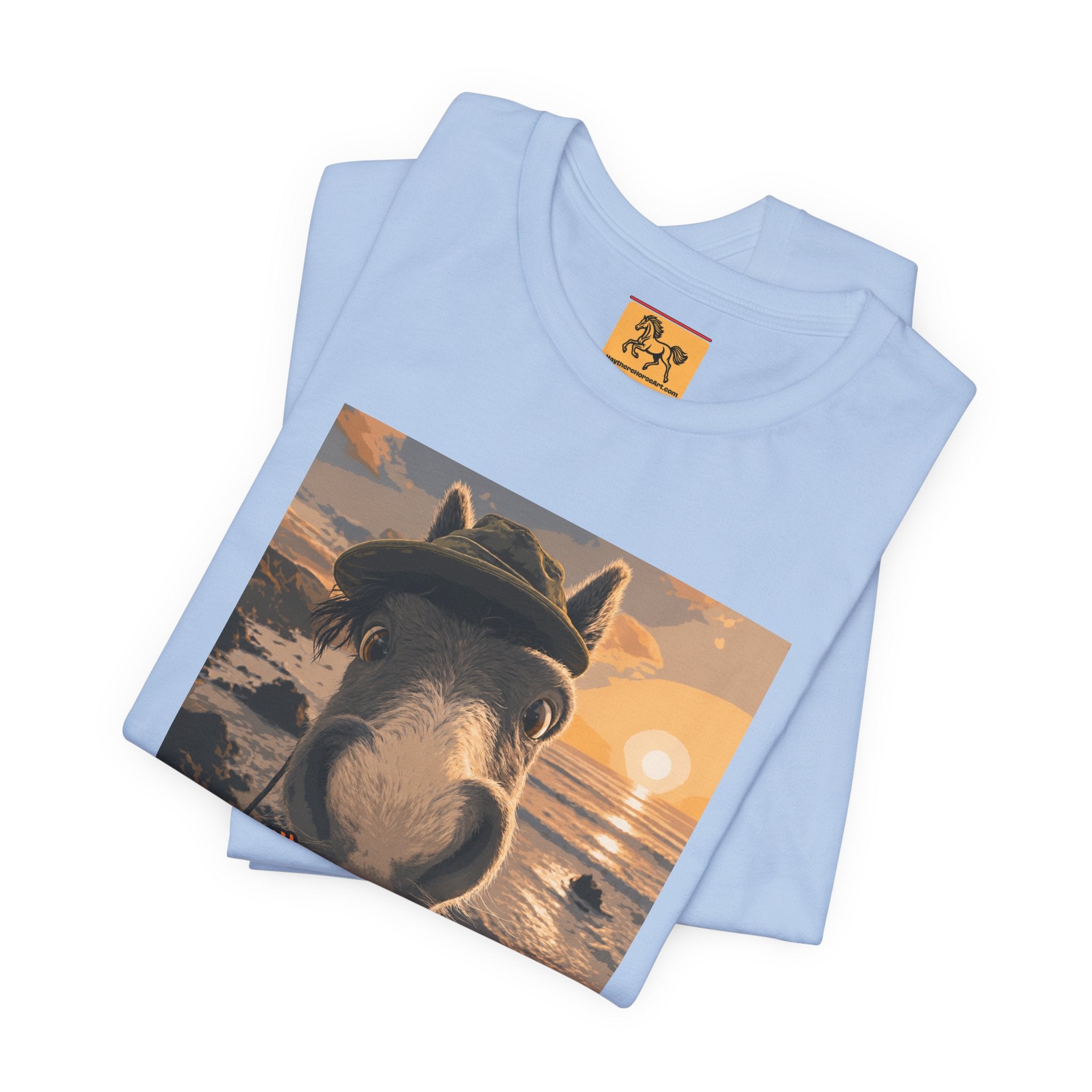 A Bella + Canvas 3001 unisex t-shirt featuring an illustrated horse taking a beach selfie at sunset, wearing a hat, with the words 'Loving my holiday XXX' in orange script. 