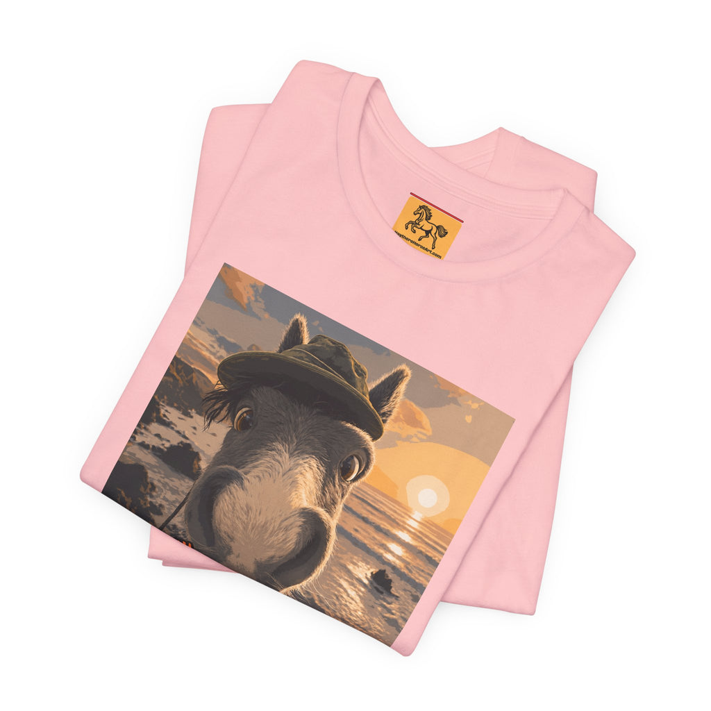 A Bella + Canvas 3001 unisex t-shirt featuring an illustrated horse taking a beach selfie at sunset, wearing a hat, with the words 'Loving my holiday XXX' in orange script. 