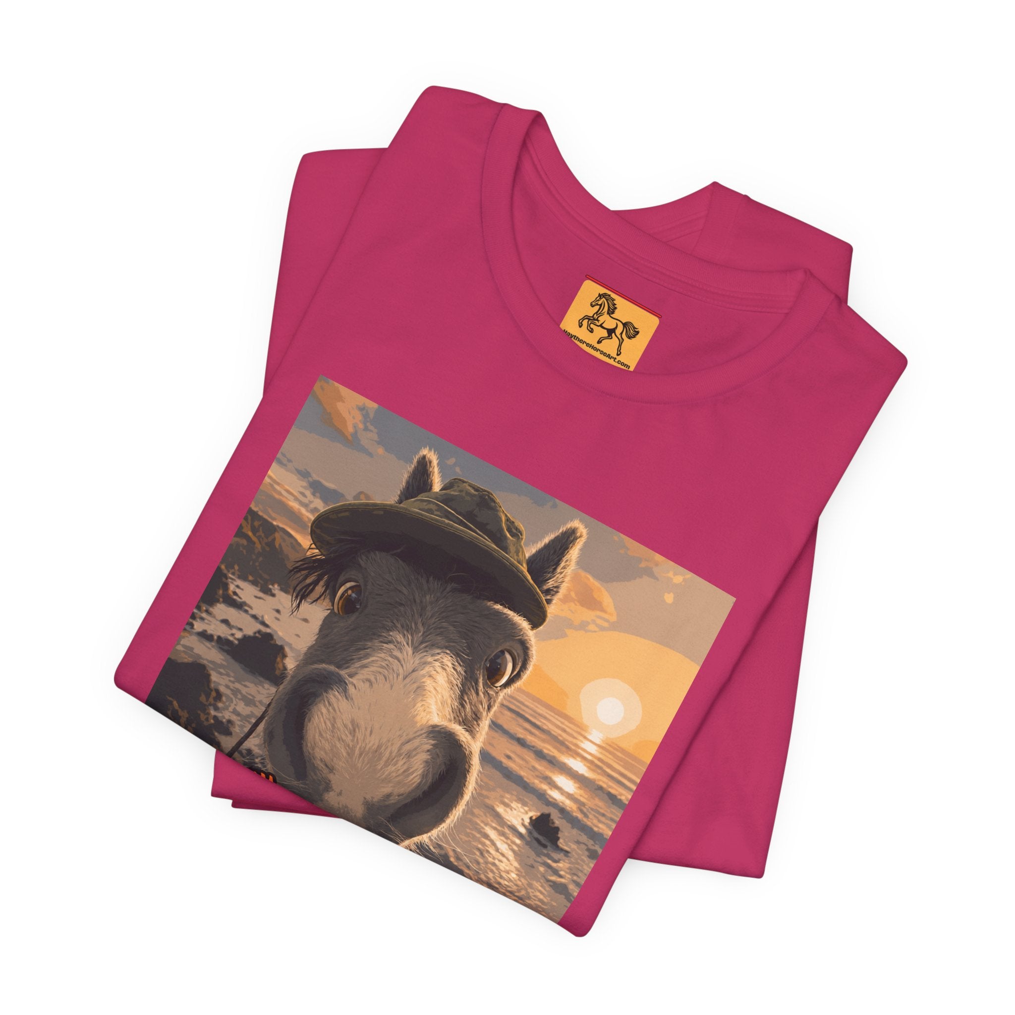 A Bella + Canvas 3001 unisex t-shirt featuring an illustrated horse taking a beach selfie at sunset, wearing a hat, with the words 'Loving my holiday XXX' in orange script. 