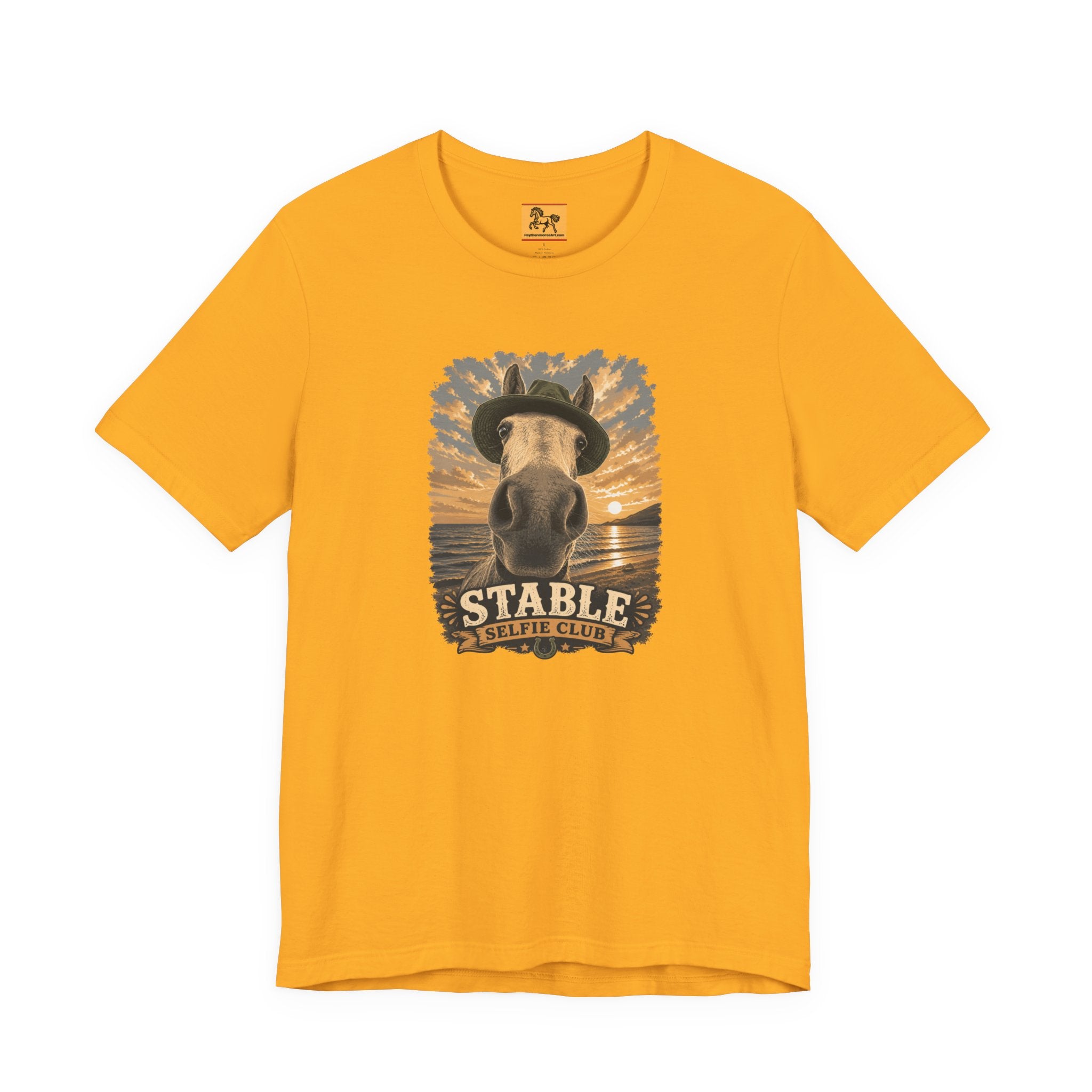 Stable Selfie Club unisex t-shirt in gold, featuring original equestrian artwork of a horse wearing a hat taking a selfie at sunset on a beach, printed on Bella & Canvas 3001 tee by Hay there Horse Art.
