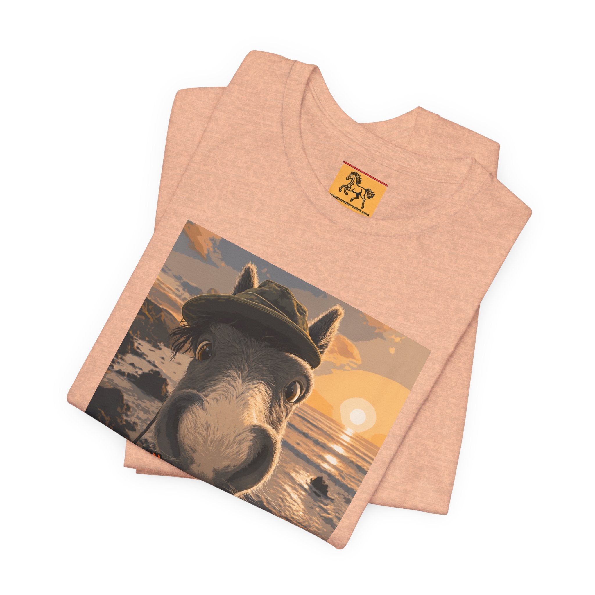 A Bella + Canvas 3001 unisex t-shirt featuring an illustrated horse taking a beach selfie at sunset, wearing a hat, with the words 'Loving my holiday XXX' in orange script. 