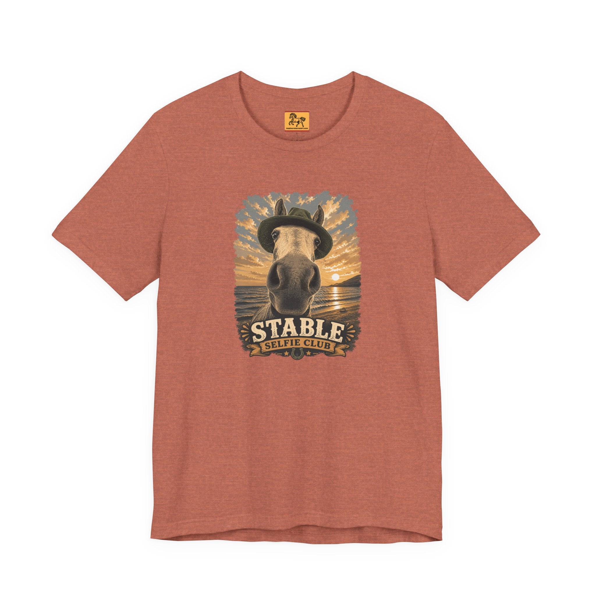 Stable Selfie Club unisex t-shirt in heather clay, featuring original equestrian artwork of a horse wearing a hat taking a selfie at sunset on a beach, printed on Bella & Canvas 3001 tee by Hay there Horse Art.